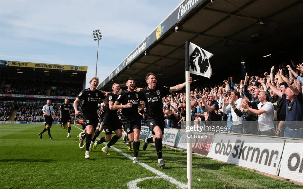 黑马球队在预选赛中庆祝进球，球迷看台热烈